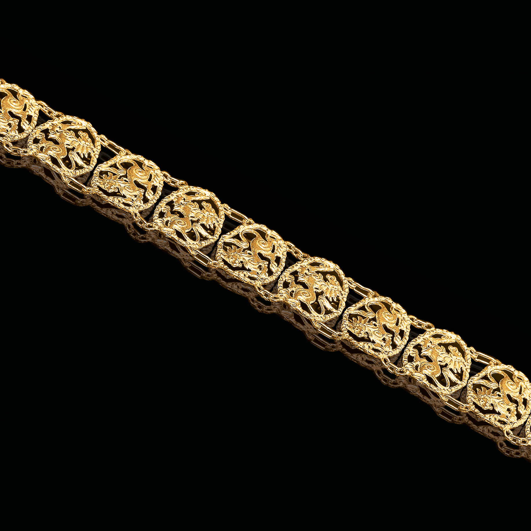 Gold bracelet with intricate design on a black background