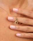 Gold necklace with a 'B' pendant on a person's neck
