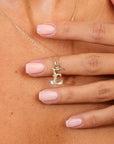 Gold necklace with an E pendant worn by a person