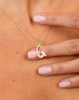 Gold necklace with a letter 'G' pendant on a person's neck