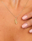 Gold necklace with a pendant on a person's neck