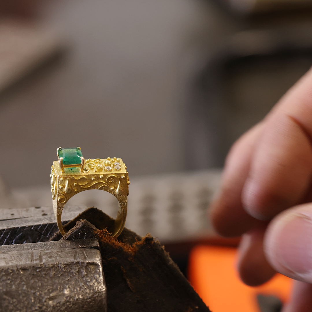 Close up of high jewelry emerald ring in gold and diamonds