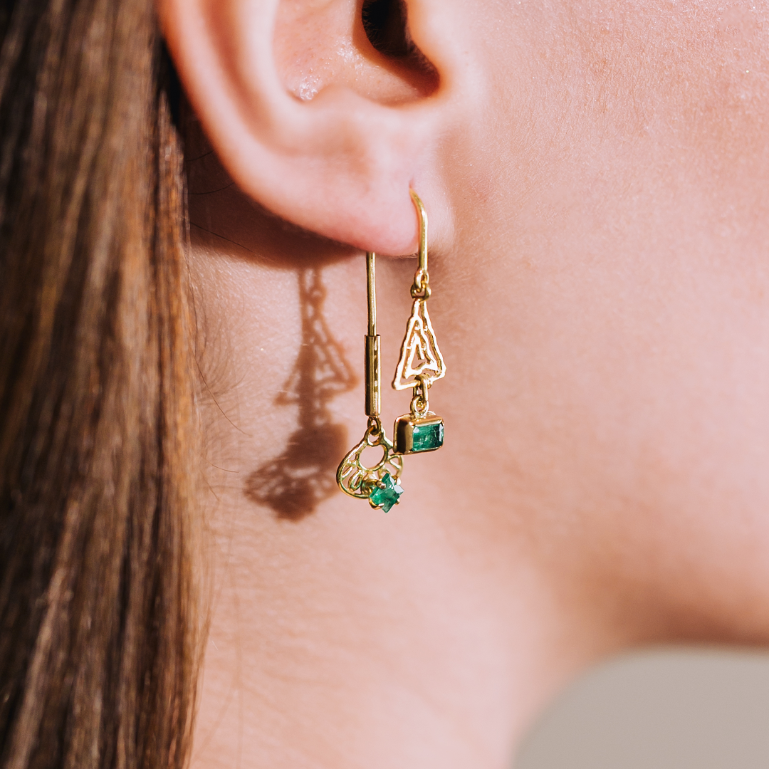 Model_wearing_gold_and_emerald_unique_designer_jewelry_earrings_side_view