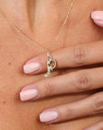 Gold necklace with a heart pendant on a person's wrist