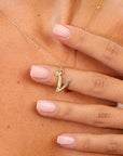 model wearing V initial on a golden chain
