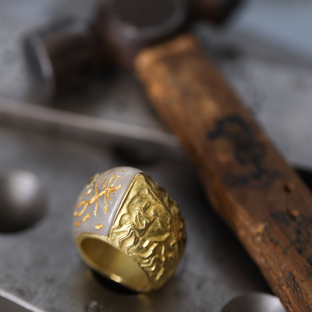 Behind the scenes at Marilisi Jewelry Atelier, showcasing a handcrafted sculptural gold ring resting on the artisan’s workbench with traditional goldsmithing tools. Fine jewelry craftsmanship for collectors and connoisseurs.