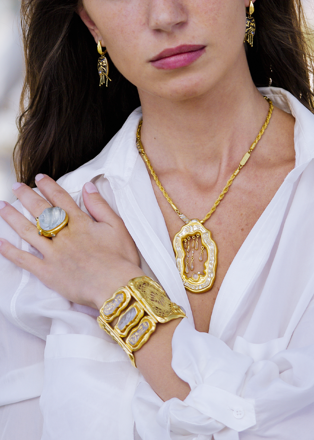 Blue Ocean Collection luxury gold jewelry styled on model, featuring sculptural cuff bracelet, statement natural stone ring, handcrafted pendant necklace, and artistic earrings by Marilisi. Designed for collectors seeking one-of-a-kind fine jewelry.