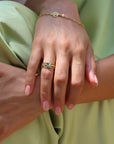 Marilisi emerald and diamond gold openwork ring worn by model in green suit, artisan fine jewelry for collectors