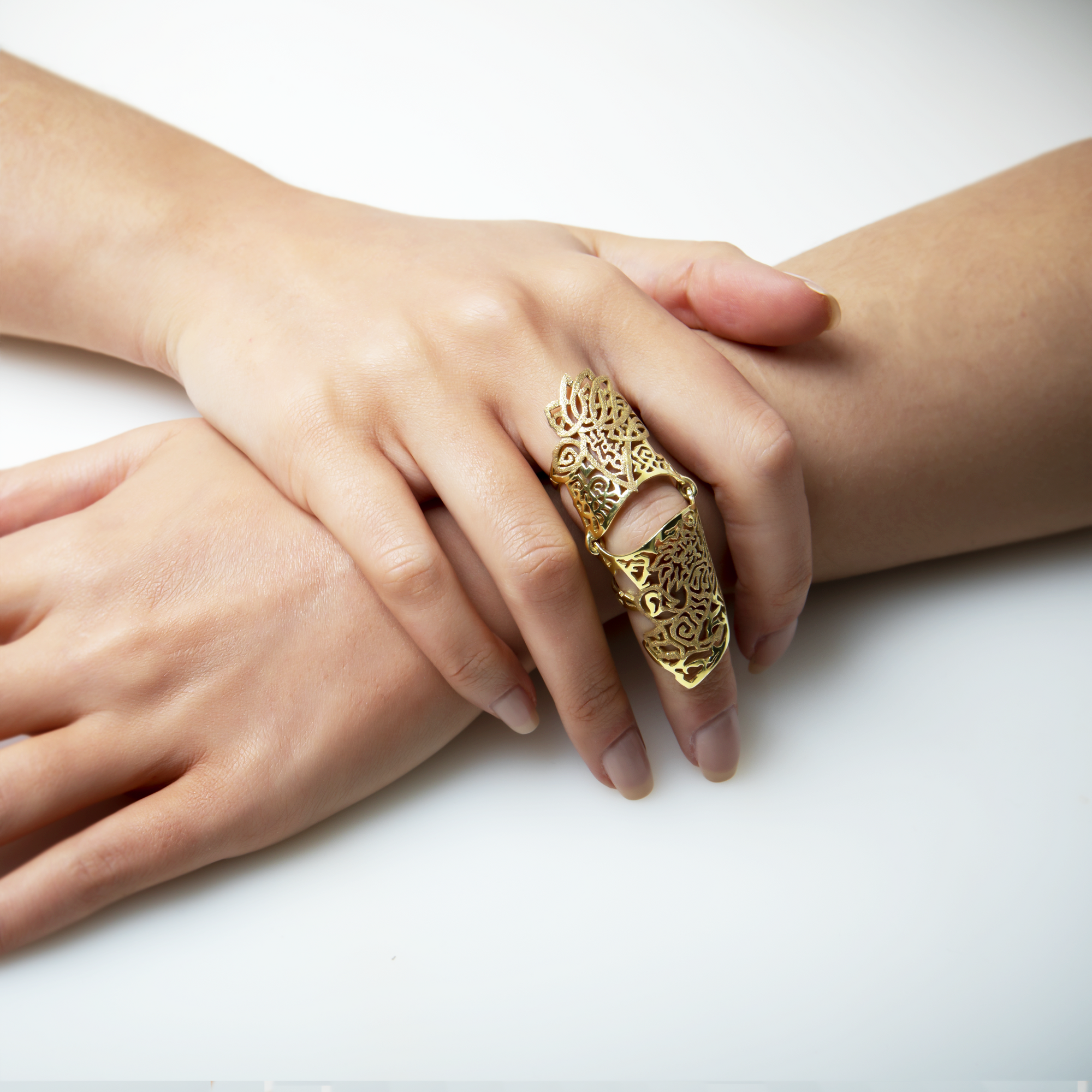 Gold Armour ring on a model’s hand depicting Aztec mythology and struggle for power