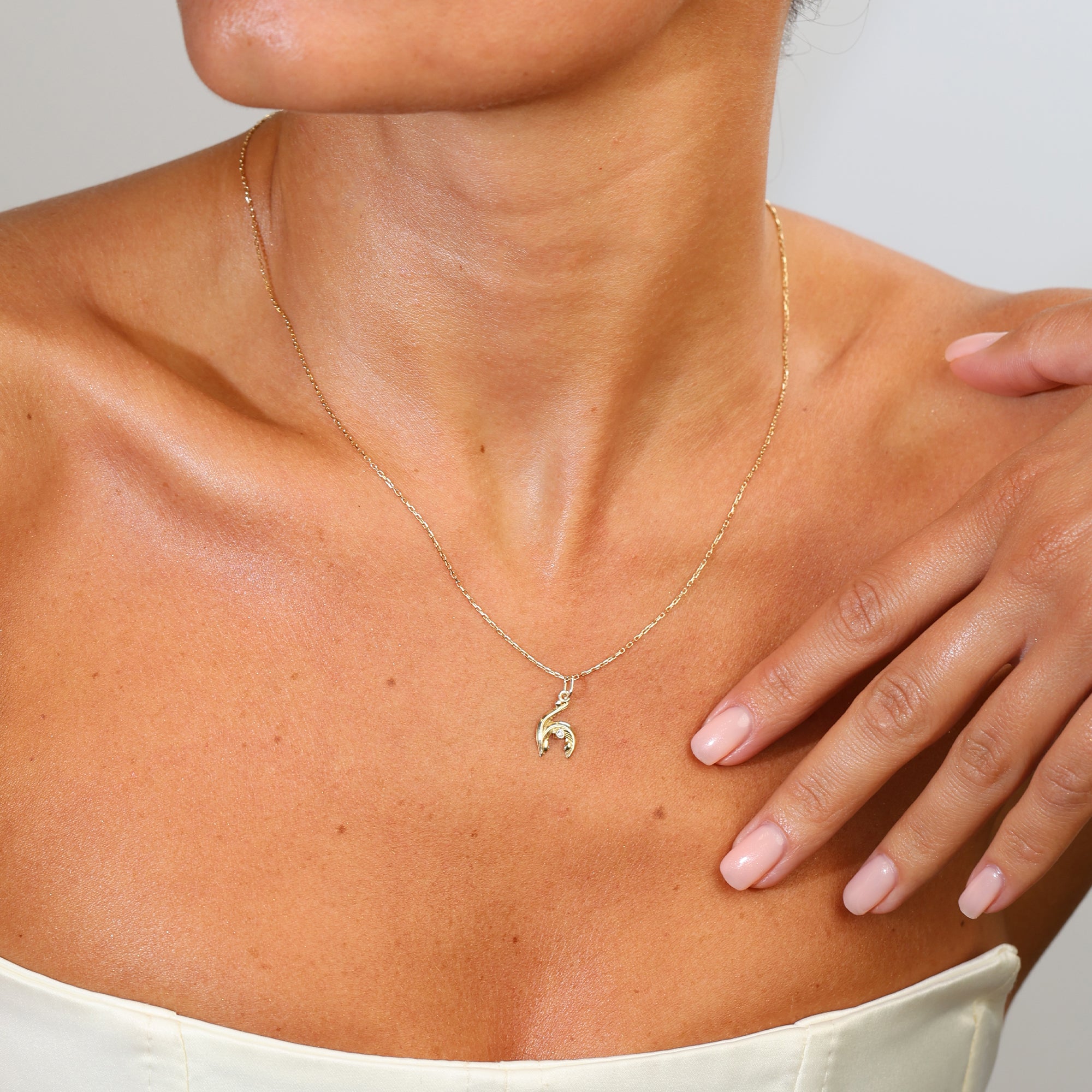 Gold necklace with on a person's neck