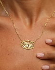 Gold handmade chain necklace with a handcrafted lion pendant worn by a person