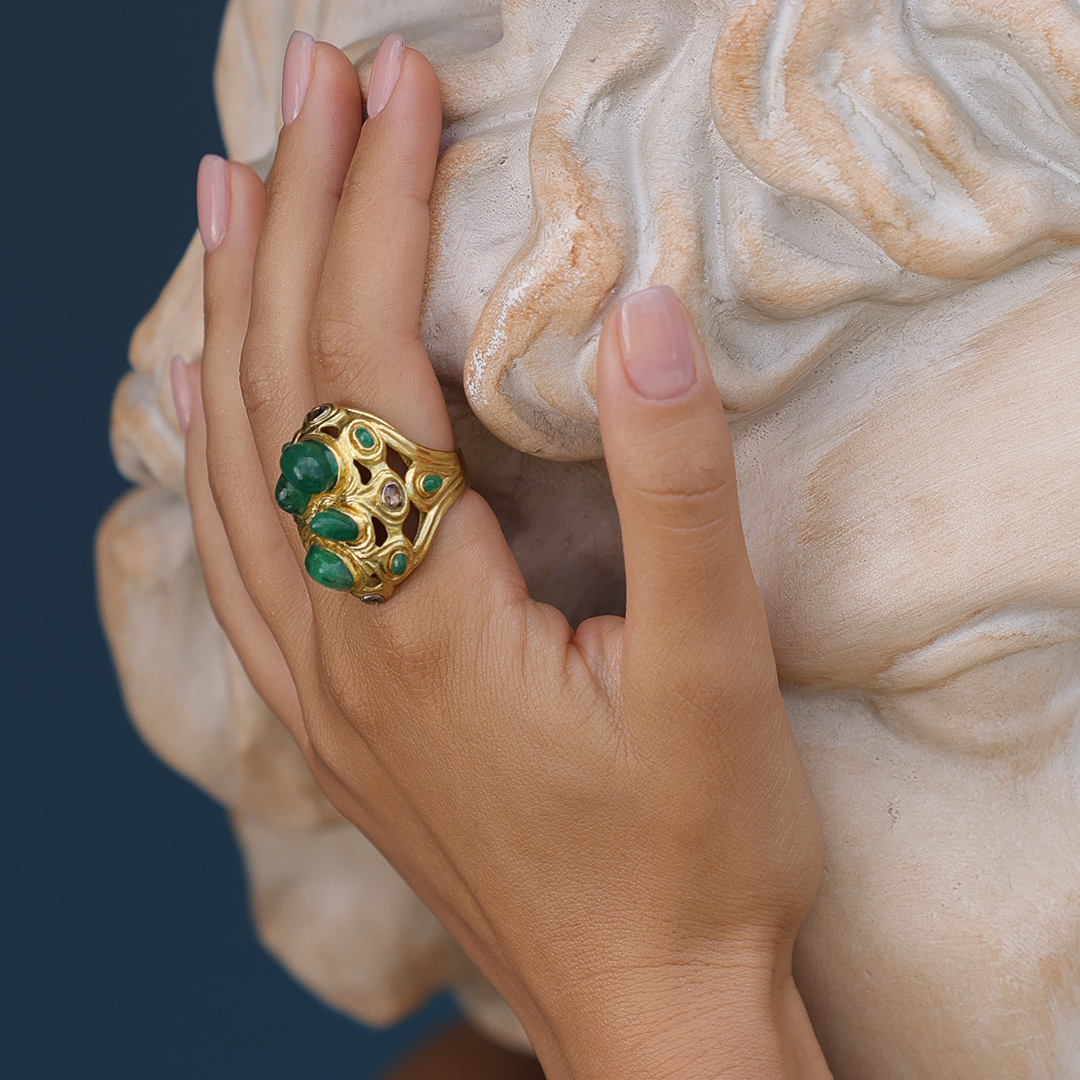 Hand with a large decorative ring on a marble bust background
