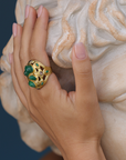 Hand with a large decorative ring on a marble bust background